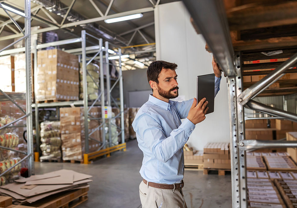 man in a warehouse doing inventory checks with a tablet